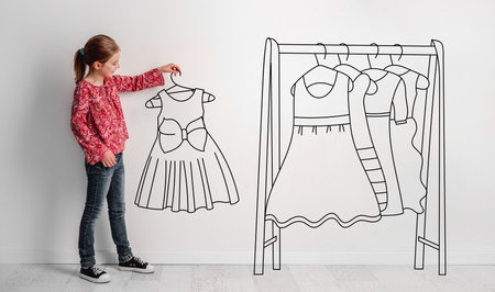 Photo Of Little Girl Holding Hand-Drawn Dress, With Illustrated Hanger And Dresses Nearby, Combines Photography And Illustration On The Theme Of ChildrenS Fashionの写真素材