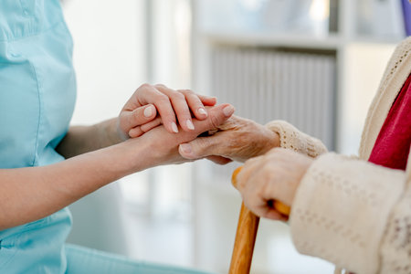 NurseS Hand Holding Elderly WomanS Hand With A Cane And NurseS Hand Holding Pills That Elderly Woman Is Taking, Are Captured In Close-Upの写真素材