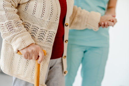 Nurse Helps Elderly Woman Walk In Nursing Homeの写真素材