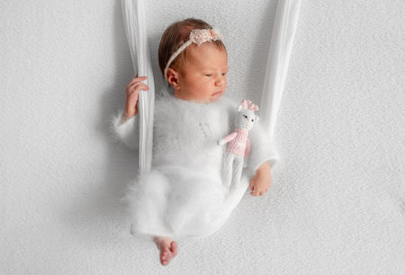 Newborn Girl On Improvised Swing During A Baby Photo Session In Studioの写真素材