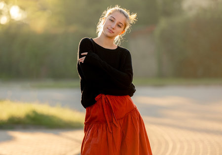Beautiful teenager girl posing in park outdoors at nature. Pretty teen model in trendy clothes at street portraitの写真素材