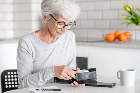 Smiling Elderly Woman Counts Euro Money In Walletの写真素材