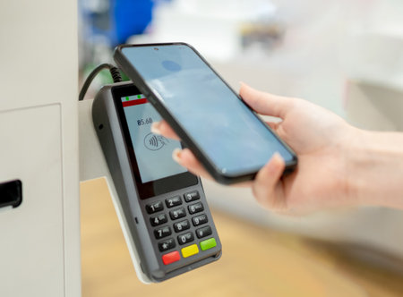 Girl Pays For Purchases At Self-Service Checkout Terminal, Close-Up Of Hands