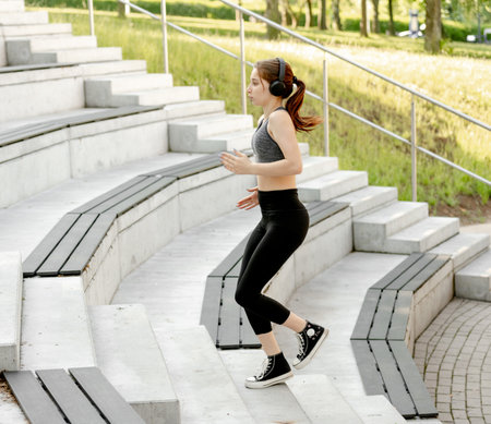 Young Girl Exercises By Running Up And Down Stairs Outdoorsの写真素材