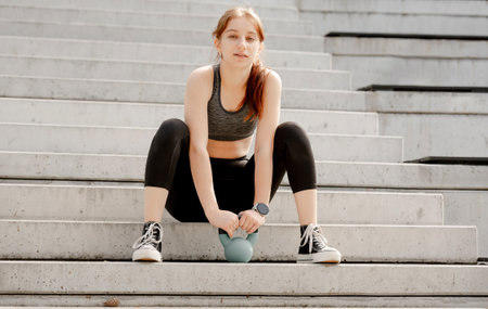 Sporty Lifestyle Girl Poses With Kettlebell In Parkの写真素材