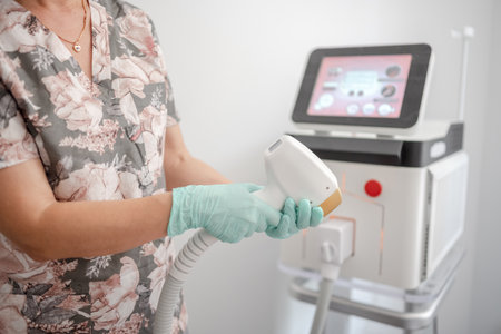 Master Of Laser Hair Removal Adjusts Equipment Before Procedureの写真素材