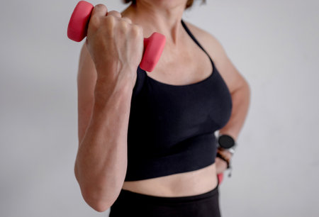 WomanS Hand With Dumbbells Close-Up Doing Bicep Exerciseの写真素材