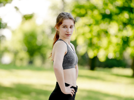 Teenage Girl Poses In Sportswear In Park During Summer