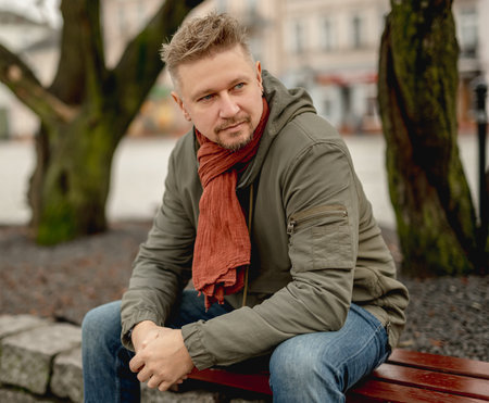 Young Attractive Man On Park Bench, Autumn City Portraitの写真素材
