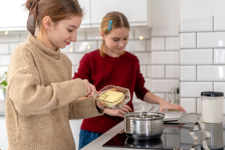 Two Little Sisters Cooking At Home In The Kitchenの写真素材
