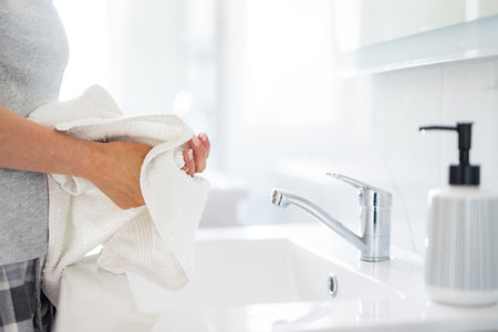 Woman Drying Hands At Home In The Bathroom Close-Upの写真素材