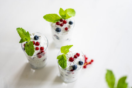 Yogurt Chia Seed Dessert With Red Currants And Blueberries On A White Table