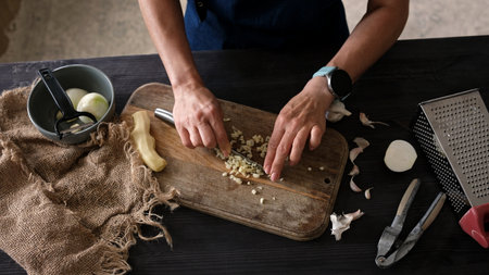 Close-Up Top View Of Woman Slicing Garlicの写真素材