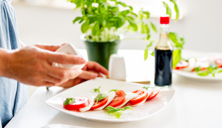 Close-Up Of Woman Making Caprese Saladの写真素材