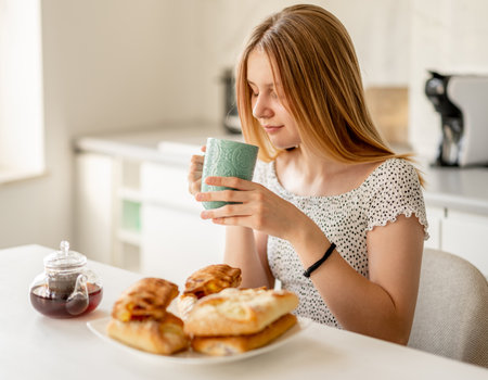 Teen Girl Having Pastry For Breakfastの写真素材