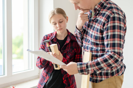 Dad And Daughter Looking At Furniture Assembly Diagram At Homeの写真素材