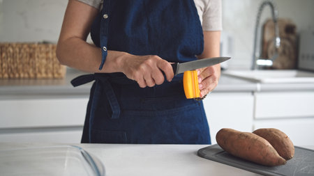 Woman Sharpening Knife In Close-Up Viewの写真素材