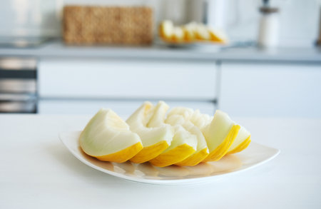 Sliced Melon On A Plate Against A Kitchen Backgroundの写真素材