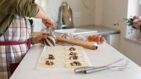 Woman Baking Cookies And Applying Chocolate Cream To The Pieces Of Doughの写真素材
