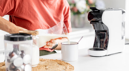 Woman Adding Milk To Coffee At Home, Close-Up