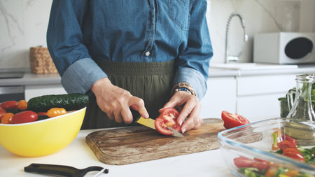 Woman Cutting Tomato For Saladの写真素材