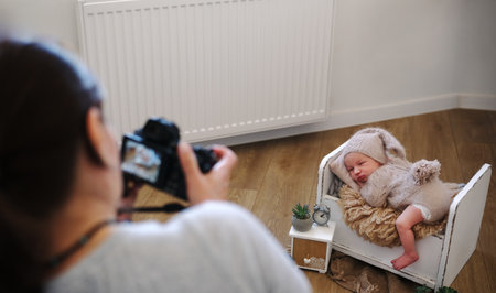 Newborn Photographer Taking Baby Pictures Backstage At A Newborn Photoshootの写真素材
