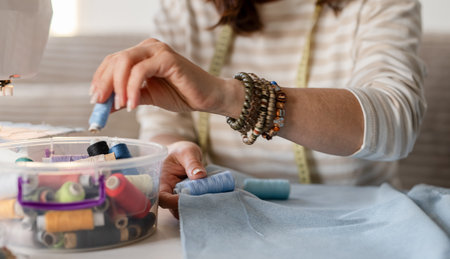 Seamstress Matches Thread To Fabric Color With Hands Up Closeの写真素材