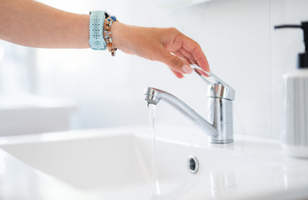 Woman's Hand Turns Off Faucet Water In The Home Bathroom, Close-Up