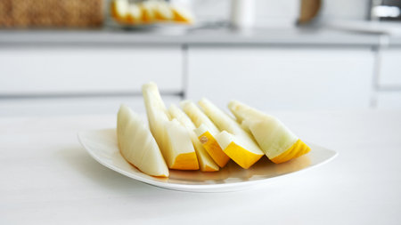 Sliced Melon On A Plate Against A Kitchen Backgroundの写真素材