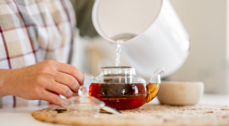 Close-Up Of Woman Pouring Tea Into Mugの写真素材