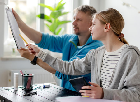 Girl Doing Homework With Dad At Homeの写真素材