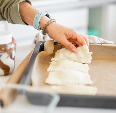 Close-Up Of Woman Placing Stuffed Cookies On Baking Tray