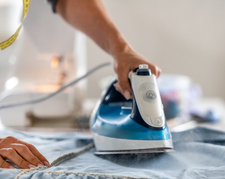 Close-Up Of Woman Ironing Fabric Before Sewingの写真素材