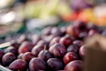 Close-Up Of Plums Sitting On Market Stallの写真素材