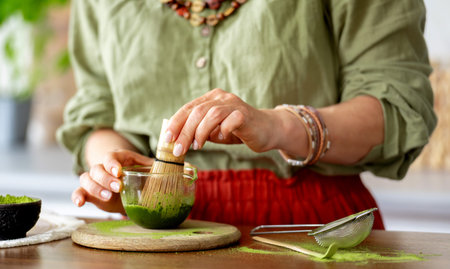 Close-Up Of A Woman Whisking Matcha Green Teaの写真素材