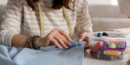 Seamstress Matches Thread To Fabric Color With Hands Up Closeの写真素材