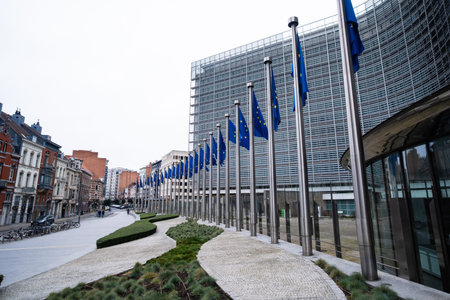 EU Flags On Poles Displayed In Front Of The European Commission Facade In Brussels Belgium