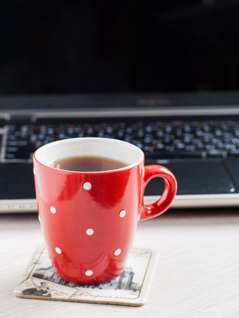 Red cup in pea on a laptop screen background.の写真素材