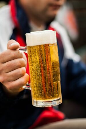 glass of beer in his hand man close-up.の写真素材