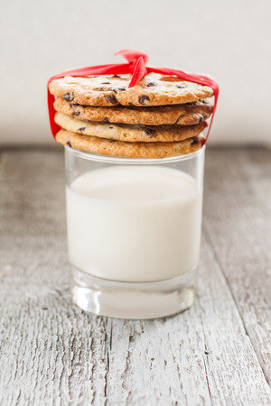 Great American Cookies with chocolate and a glass of milk.の写真素材