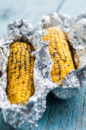 Baked corn closeup on wooden background.の写真素材