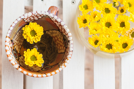 yellow flowers in a cup of tea.の写真素材