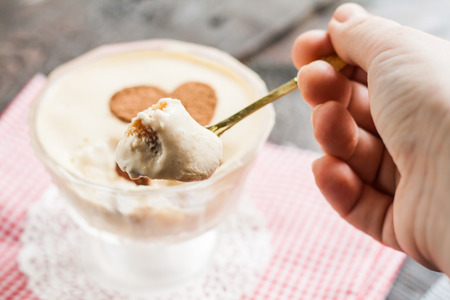 Tiramisu on a spoon in his hand.の写真素材