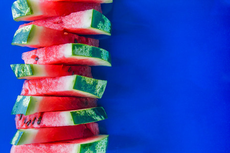 Tower of slices of watermelon on a blue background.の写真素材