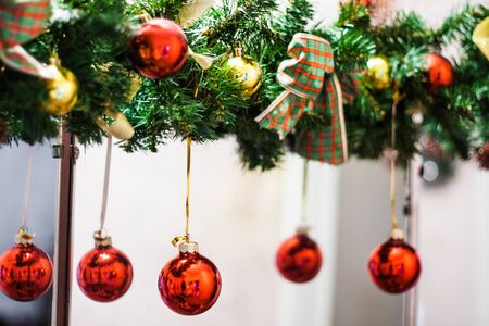 decorated Christmas tree garland with red balls and bows.の写真素材