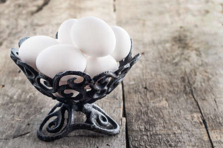 raw chicken white eggs in an iron antique vase.の写真素材
