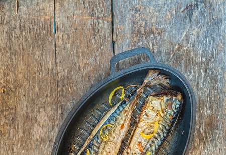 fish mackerel with a metal mold for baking wooden table.の写真素材