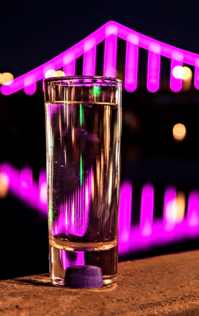 reflected in the glass with night lights burning bridge water.の写真素材