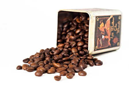 Coffee beans are scattered from stain-roof bank close up isolatedの写真素材