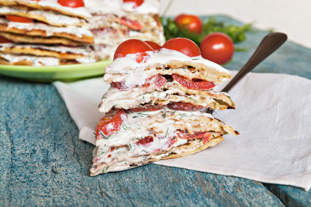 zucchini cake with tomato and parsley on a blue wooden background